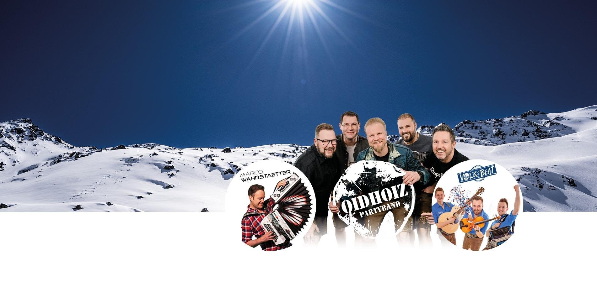 A group of musicians stands in front of a snowy mountain landscape. In the background, the sun shines in the clear sky.