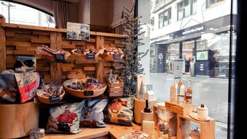 An inviting showcase with wooden shelves displaying various products. In the background, healthy snacks and drinks are visible, while the city street can be seen through the window.