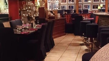 A cozy restaurant with elegant tables and an inviting atmosphere. In the upper area, various delicacies and drinks are depicted.