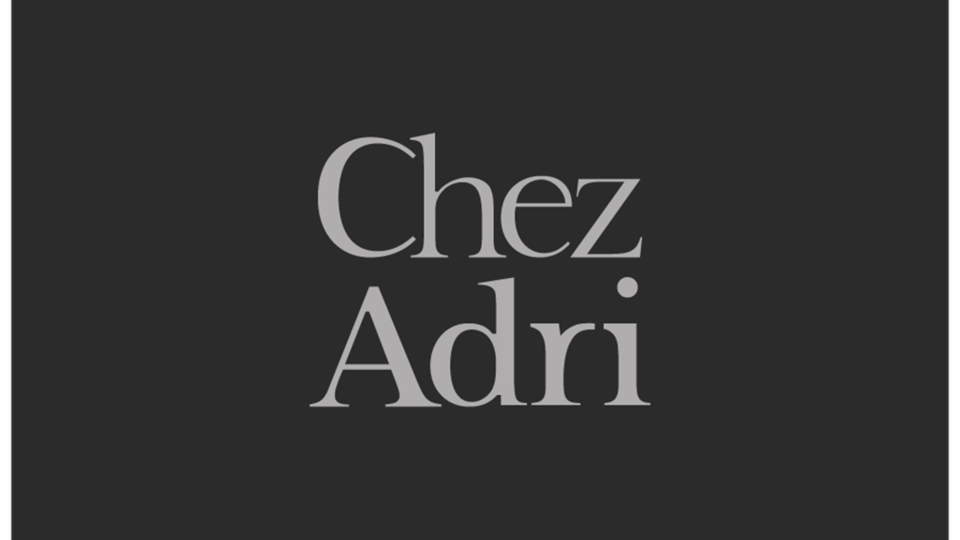 A simple, elegant logo with the text "Chez Adri" in gray lettering. The background is dark, which enhances the design.