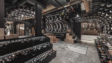 Ein eleganter Weinraum mit Regalen voller Weinflaschen. Die moderne Einrichtung vermittelt eine stilvolle Atmosphäre.