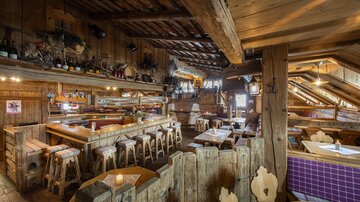 A cozy restaurant with wooden furniture and rustic decor. The atmosphere feels inviting and warm.