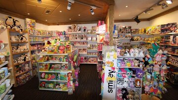 A toy store full of colorful plush toys and games. The shelves are filled to the ceiling with various items.