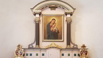 A beautiful altar with a painting of the Virgin Mary and a child. The golden embellishments give the artwork a special elegance.