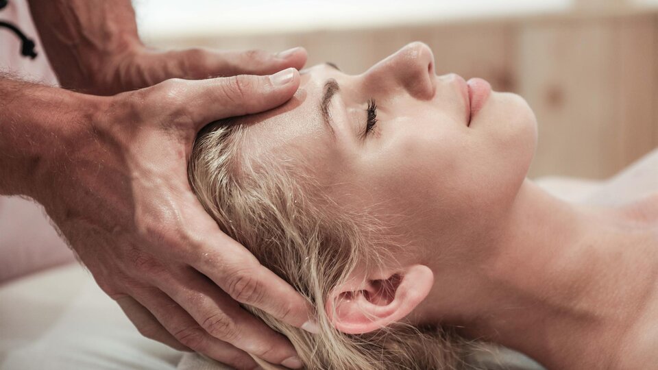 A woman receives a relaxing head massage. The atmosphere is calm and soothing.