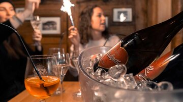 Eine festliche Feier mit Sekt und glitzernden Wunderkerzen. Das Ambiente ist gemütlich und ansprechend.