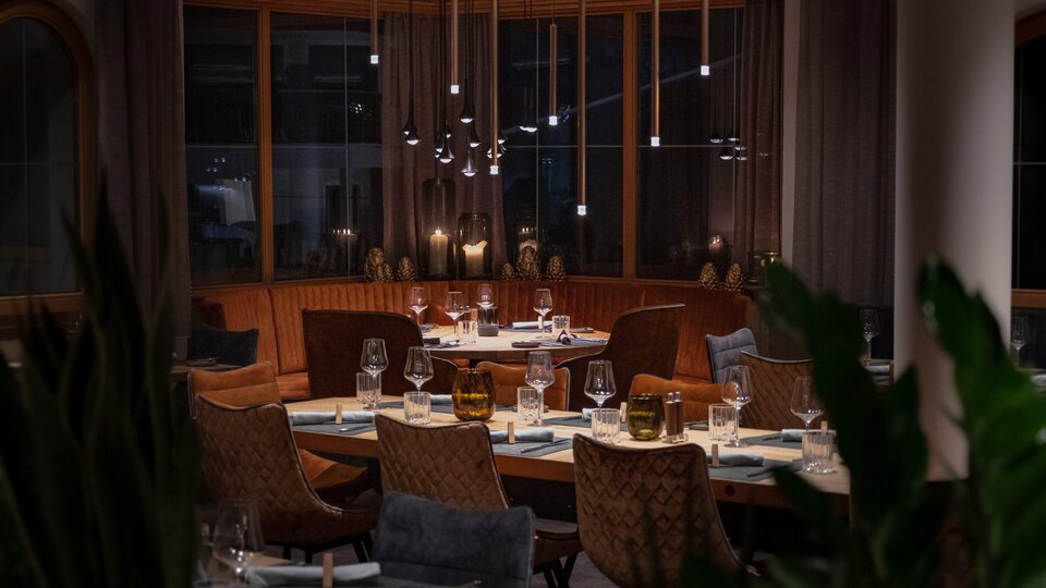 Ein elegantes Restaurant mit gemütlichen Tischen und stilvoller Beleuchtung. Die warmen Farben und das ansprechende Interieur schaffen eine einladende Atmosphäre.