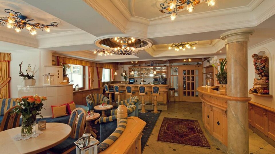 Ein elegantes Café mit gemütlichen Sitzmöglichkeiten und stilvollen Leuchten. Die Einrichtung ist warm und einladend, ideal für Entspannung und Geselligkeit.