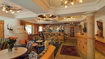 Ein elegantes Café mit gemütlichen Sitzmöglichkeiten und stilvollen Leuchten. Die Einrichtung ist warm und einladend, ideal für Entspannung und Geselligkeit.