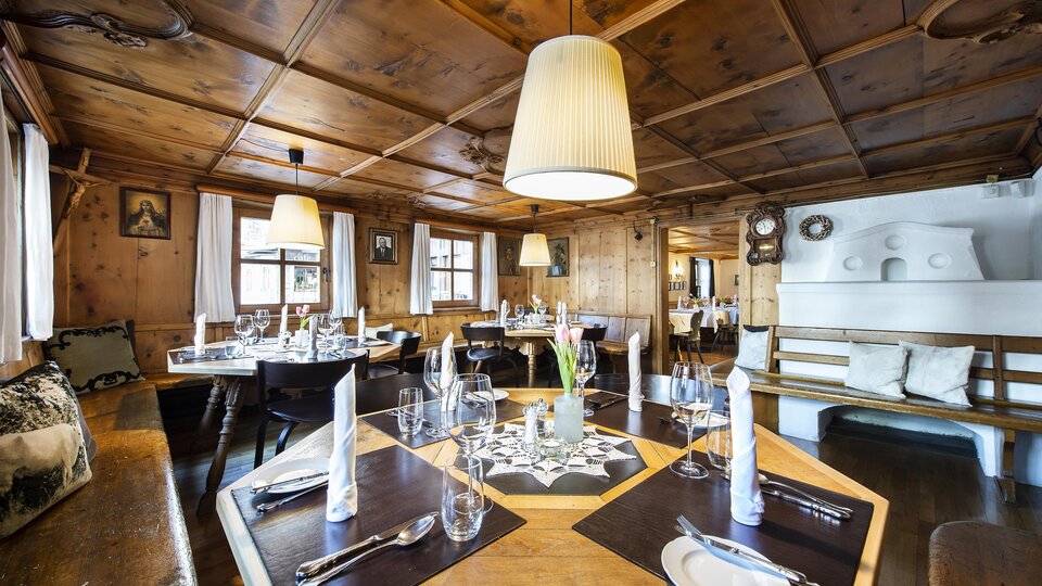 Ein gemütliches Restaurant mit Holzverkleidung und eleganten Tischen. Die warme Beleuchtung schafft eine einladende Atmosphäre.