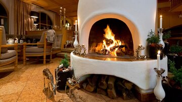 Ein gemütlicher Kamin mit flammendem Feuer und stimmungsvollem Licht. Die Umgebung ist warm und einladend, ideal für entspannende Abende.
