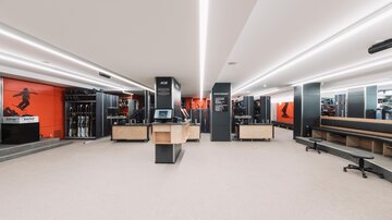 A modern sales room with bright, minimalist design. Sportswear and equipment are displayed on the walls.