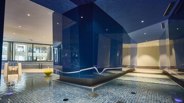A modern wellness area with blue walls and a pool. The environment feels relaxing and inviting.