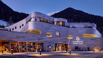 A modern building with an elegant facade in the mountains. The entrance is inviting and stylishly designed.