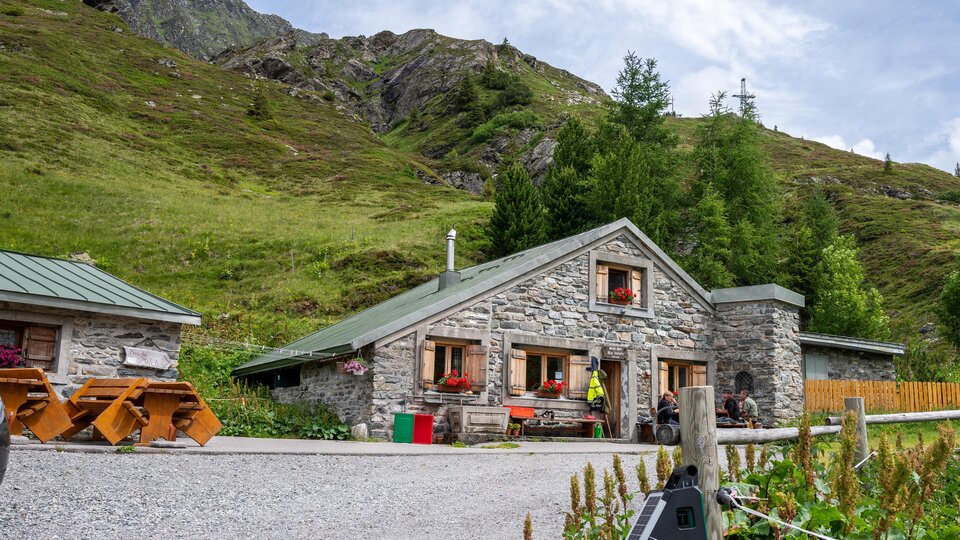 A cozy stone house in a picturesque mountain landscape.  
Surrounded by green meadows and mountains, it is an idyllic retreat.