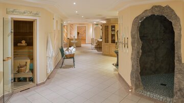 A tranquil wellness area with a sauna and a steam bath. The walls are in warm colors and invite relaxation.