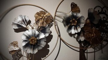 Dekorative Blumenarrangements in modernen Metallringen. Die Blumen sind in verschiedenen Farben gehalten und verleihen dem Raum einen eleganten Akzent.