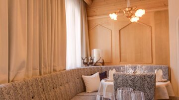 Ein elegantes Restaurant mit einem gemütlichen Tisch deckt. Die Einrichtung ist modern mit Holzdetails und sanften Farben.