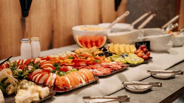 Ein reichhaltiges Buffet mit verschiedenen Meeresfrüchten, frischem Obst und Gemüse. Die Präsentation ist ansprechend und einladend.