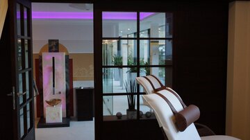 An elegant wellness area with stylish furniture and soft lighting. The atmosphere is calm and relaxing.