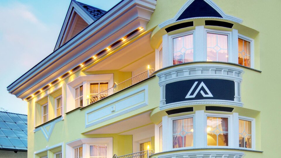 Ein modernes Hotel mit gelber Fassade und eleganten Balkonen. Das Gebäude strahlt Gemütlichkeit und einladenden Stil aus.