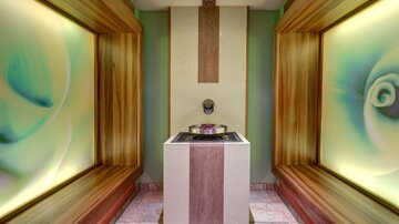 Ein stilvoller Innenraum mit sanften Farben und modernem Design. In der Mitte steht ein eleganter Tisch, umgeben von weichen Wandverzierungen.