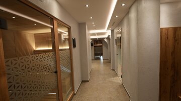 Ein moderner Flur mit hellen Wänden und eleganten Holz-Elementen. Die Deckenbeleuchtung sorgt für eine angenehme Atmosphäre.