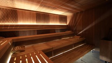 Eine moderne Sauna mit Holzverkleidung und sanfter Beleuchtung. Die Sitzbänke sind aus Holz und bieten Platz für Entspannung.