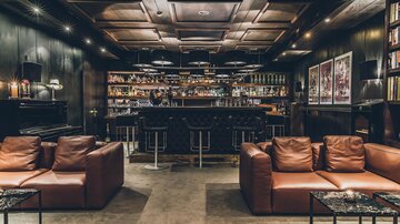 Eine stilvolle Bar mit einer eleganten Einrichtung aus dunklem Holz. Gemütliche Sofas und Tische schaffen eine einladende Atmosphäre. | © elizabeth.at