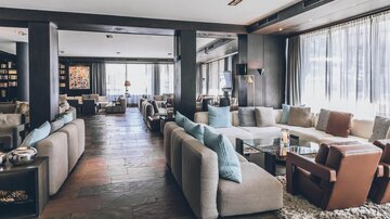 Eine moderne Lounge mit eleganten Sofas und großen Fenstern. Der Raum ist hell und einladend, ideal zum Entspannen. | © elizabeth.at