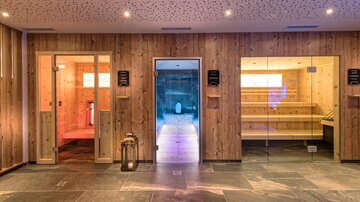 Ein modernes Spa mit Holzverkleidung und verschiedenen Saunen. Die Atmosphäre ist entspannend und einladend.