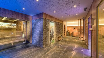 Ein stilvoller Wellnessbereich mit Holz- und Steindetails. Sanfte Beleuchtung schafft eine entspannende Atmosphäre.