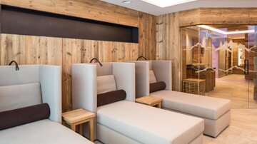 Ein moderner Wellnessbereich mit komfortablen Liegen. Die Holzwände verleihen eine gemütliche Atmosphäre.