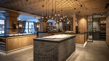 Ein modernes Restaurant mit Holz- und Steinakzenten. Die Beleuchtung erzeugt eine warme Atmosphäre.