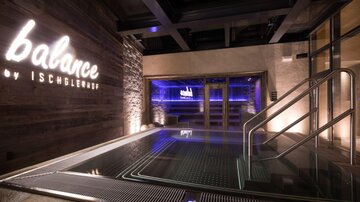 Ein eleganter Wellnessbereich mit einem Whirpool und dimmbarer Beleuchtung. Die Atmosphäre ist entspannt und modern.