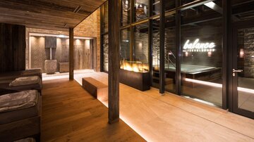 Ein modernes Wellnessbereich mit Holzverkleidung und angenehmem Licht. Im Hintergrund ist der Schriftzug „balance“ zu sehen.