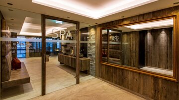 Ein modernes Spa mit Holzvertäfelung und sanfter Beleuchtung. Der Empfangsbereich ist einladend und stilvoll gestaltet.