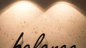 Ein elegantes Schild mit der Aufschrift "balance by ISCHGLERHOF". Es strahlt Modernität und Ruhe aus, beleuchtet von stilvollen Lampen.