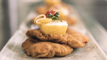 Fried platters garnished with lemon and herbs. An appetizing presentation on a long plate.