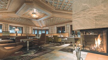 An elegant restaurant with stylish interior and cozy atmosphere. In the background is a fireplace that radiates inviting warmth.
