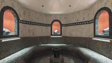 An elegant steam bath room with mosaic benches and characteristic windows. The calm atmosphere invites relaxation.