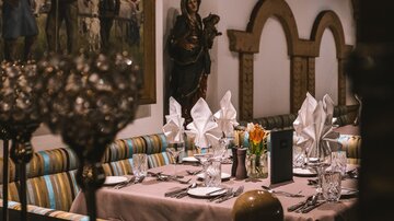 Ein elegant gedeckter Tisch in einem Restaurant mit bunten Bänken. Die Atmosphäre ist gemütlich und einladend.