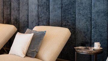 Ein eleganter Entspannungsbereich mit bequemen Liegen und sanfter Beleuchtung. Die Wände sind in einem stilvollen blauen Design gehalten.