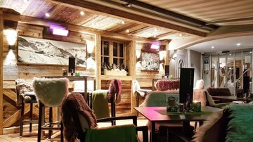 A cozy interior with wooden walls and stylish furniture. Soft lighting creates an inviting atmosphere.
