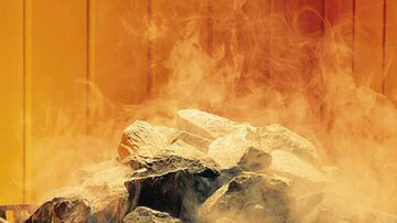 A pile of stony rocks with rising smoke. The colors in the background are orange and yellowish.