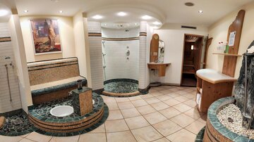 A luxurious wellness area with modern showers and a comfortable seating area. The atmosphere is relaxing and inviting.