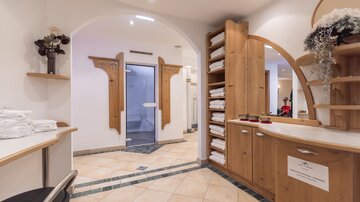 A tranquil spa area with wooden furniture and fresh towels. The soft colors create a relaxing atmosphere.