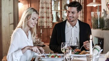 Ein stilvolles Abendessen in einem gemütlichen Restaurant. Ein Paar genießt eine Mahlzeit und hat eine angenehme Unterhaltung.